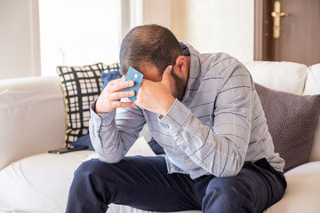male holding bank card while feeling stressed due to financial issue