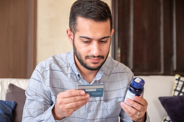 man holding bank card and medicine represent the costs of cure or treatment