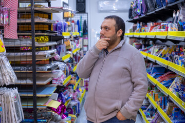 Male selecting school supplies for his kids in school supplies store