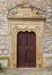 Fototapeta na wymiar Stone surround with decorative elements and bible inscription in german language on the entrance door at sebastianskirche in Kochendorf, Bad Friedrichshall in southern germany
