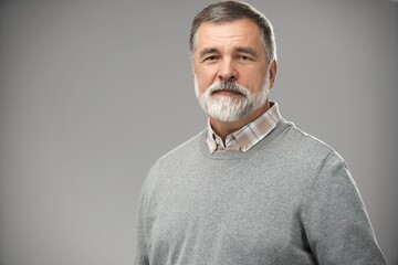 Portrait of happy casual mature man smiling, senior age man with gray hair, Isolated on gray background