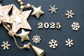Happy New Year-wooden letters and the numbers 2025 on festive black background with sequins, stars, snow. Greetings, postcard. Calendar, cover