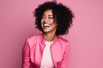Fototapeta na wymiar Portrait of a beautiful african american woman laughing against pink background