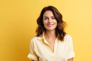 portrait of smiling young woman looking at camera isolated on yellow background