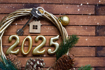 New Year House key with keychain cottage on festive brown wooden background with number 2025 in...