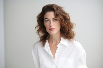 Portrait of a beautiful young woman with curly hair in a white shirt