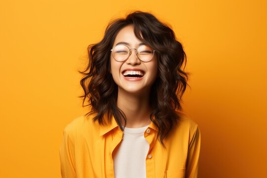 A young Asian woman with glasses is smiling.