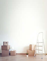 Different cardboard boxes for moving and ladder at empty room