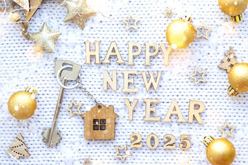 House key with keychain cottage on festive background with stars, lights of garlands. New Year 2025 wooden letters, greeting card. Purchase, construction, relocation, mortgage, insurance