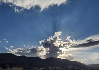 The beauty of sunshine behind white clouds with mountains in the city