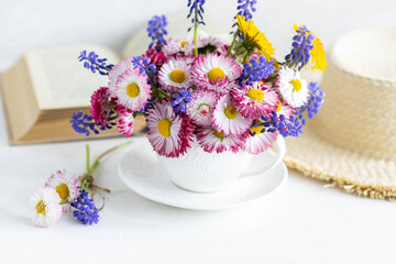 Greeting card for Women's or Mother's Day, 8th of March. Beautiful spring or summer floral composition with daisy camomile flowers in a white cup for countryside table decor. Wooden background