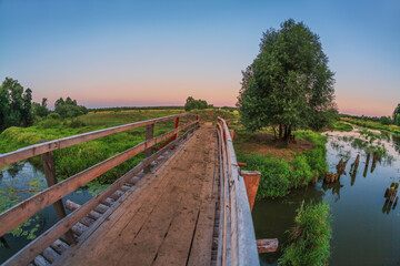 Bridge over a swampy river in sunset time