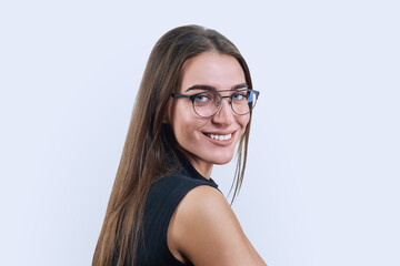 Headshot portrait of young woman in trendy glasses on white background