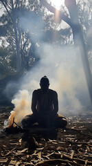 Obraz premium Traditional Ritual: An Aboriginal Man Kneeling Behind Smoke During a Smoking Ceremony, Engaging in a Reverent and Time-Honored Cultural Practice