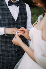 The image is of a man and a woman holding hands. They are wearing formal attire, and it appears to be a wedding