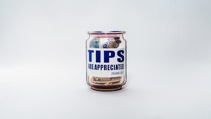 Jarro de propinas con billetes y monedas de varias denominaciones. Propinas de la industria de servicios, salario mínimo y concepto de propina como una forma única y creativa de almacenar dinero