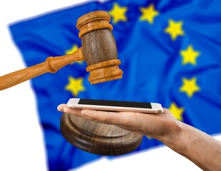 Modern smartphone, court wooden gavel and EU flag