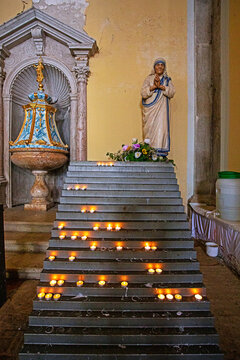 candles on the steps to the statue of the Mother of God