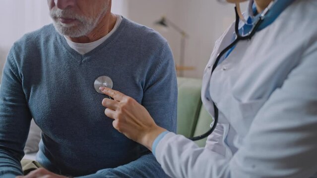 Cropped view of the woman doctor using stethoscope to listen senior elderly patient lunges