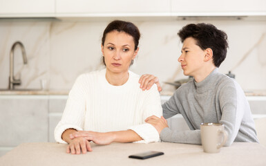 Fototapeta premium Teen son trying to apologize to his offended mother after home disagreements