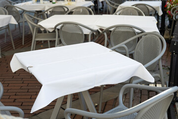Dining outdoors. Outdoor street cafe tables ready for service. Empty cafe terrace with table and chair. Table of outdoor cafe on sidewalk
