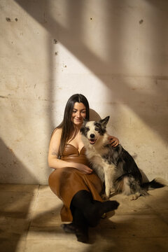 Woman in a golden dress enjoying time with her dog