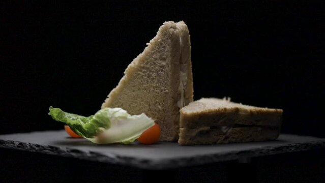 Sandwich bacon y huevo rotando con fondo negro
