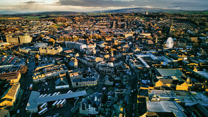 Aerial view of a city Lancaster at sunset with warm lighting highlighting the buildings and streets, showcasing the urban landscape.