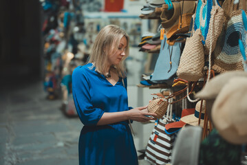 Woman choosing a bag at the evening bazaar.