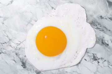 Tasty fried egg on the marble desk