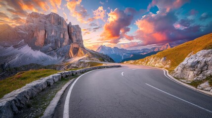 Mountain road at colorful sunset in summer. Dolomites, Italy. Beautiful curved roadway, rocks, stones, blue sky with clouds. Landscape with empty highway through the mountain pass in spring. Travel - obrazy, fototapety, plakaty