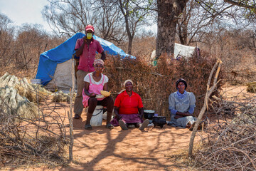 African family , lunch time in the village ,shack ,outdoors kitchen , working camp cutting thatch...