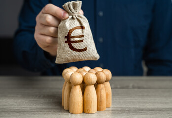 A man is holding a euro money bag over a group of people figurines. Generation of funds from...