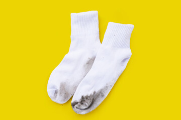Dirty white socks on yellow background.
