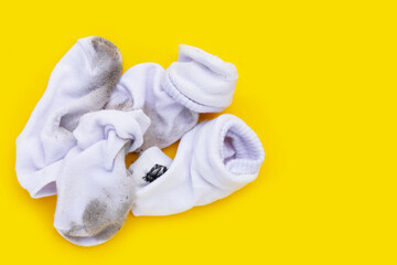 Dirty white socks on yellow background.