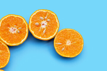 Vitamin C pills with  fresh orange citrus fruit isolated on blue background.