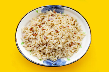 Cooked brown rice on yellow background.