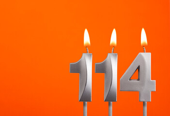 114 candle - Birthday celebration on orange background