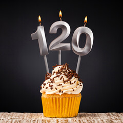 Birthday candle number 120 - Anniversary cupcake on black background