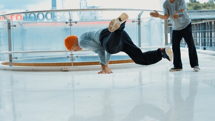 Hipster perform break dance while friend encourage him at mall. Diverse or multicultural street dancer clapping hands while watching young dance practice street dance. Outdoor sport 2024. Endeavor.