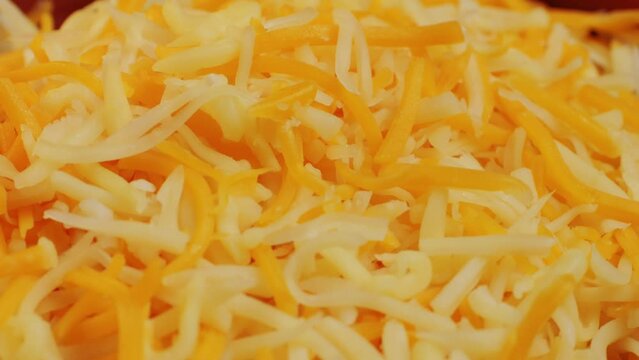 Some different sorts of grate cheese on plate close up macro. Chef grating cheese mozzarella, cheddar for meals. Itallian food, pizza, pasta. 