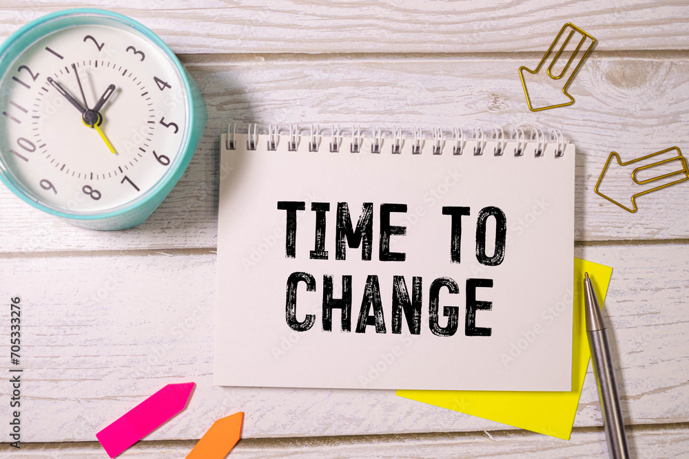 Poster an alarm clock and a white notepad that says time to change