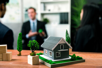 Model showcase eco house and housing business concept while business people on meeting in blur...