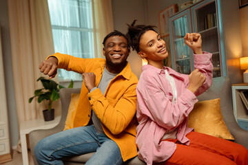 Authentic young African American couple, smiling man and woman wearing casual clothes, dancing