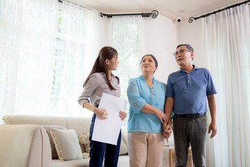 Happy couple elderly looking new home while agent real estate explaining and visit, realtor talking...