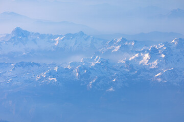 Aerial view of the Himalayas with snow capped peaks . Aerial winter scenery with mountains