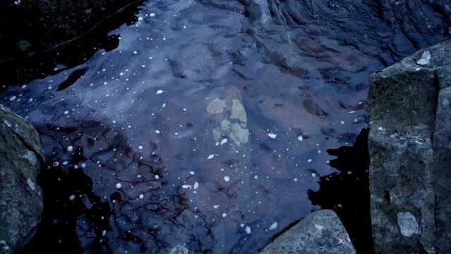 slow motion churning river eddy in scour pool created by boulder configuration