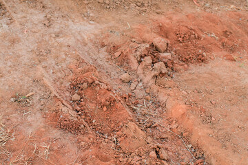 Red gravel dirt road. Textures of ground with stones. Dry soil with crack for background. Close up Land surface.