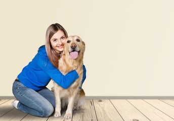 Happy young woman hugging her dog at cozy home.