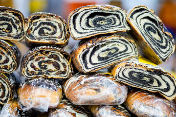Simtalapis, traditional Lithuanian cake made of yeast dough and poppy seeds, for sale at outdoor farmers market in Vilnius. - obrazy, fototapety, plakaty